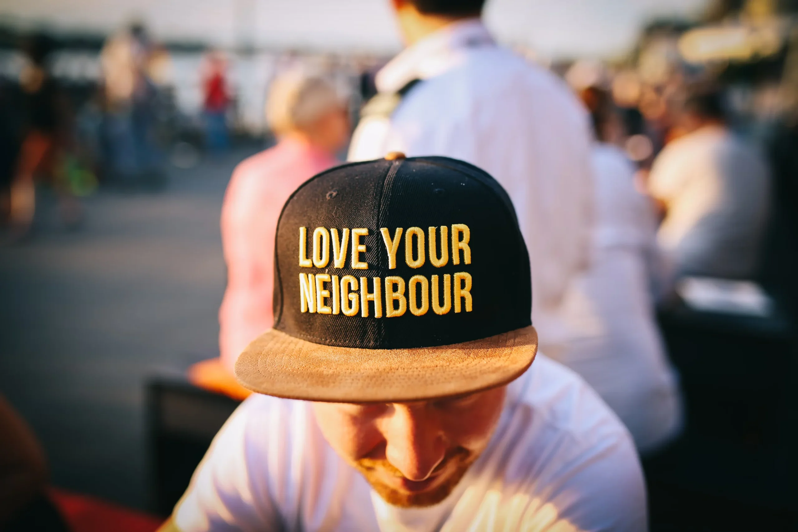 Person med svart keps med texten "Love your neighbour"